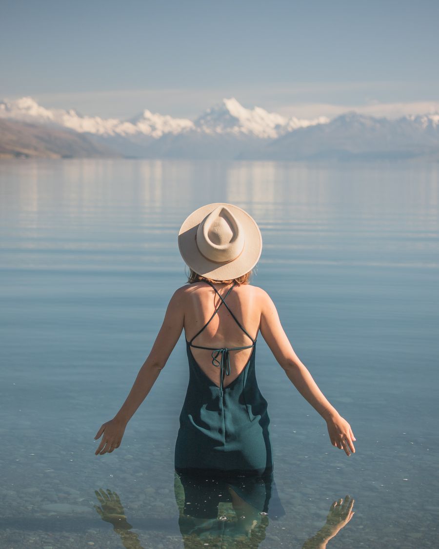 Abigail Hannah in a wide-brimmed hat looking out over Lake Pukaki