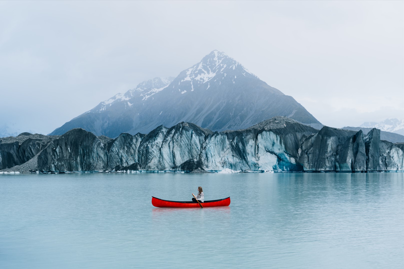 woman in a red canoe at tasman glacier